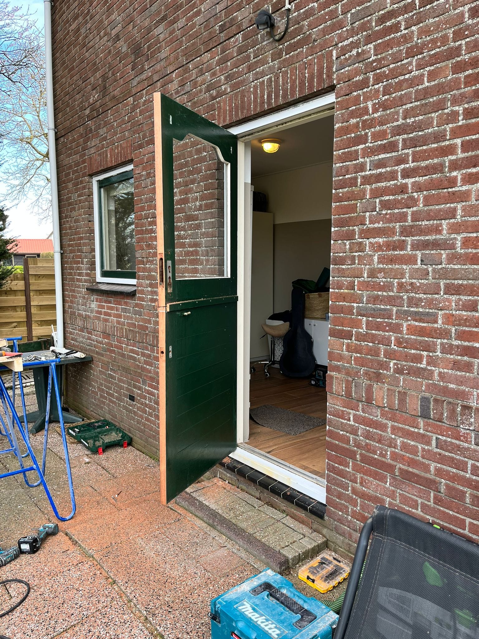 Nieuwe donkergroene staldeur in een bakstenen muur